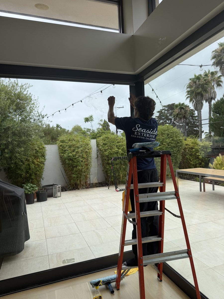 Seaside technician cleaning a large glass wall